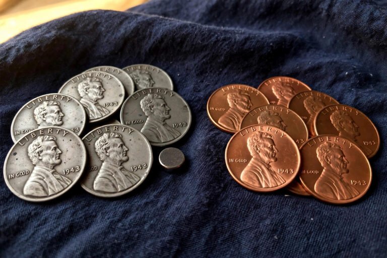 Grey 1943 steel pennies beside copper pennies with a magnet